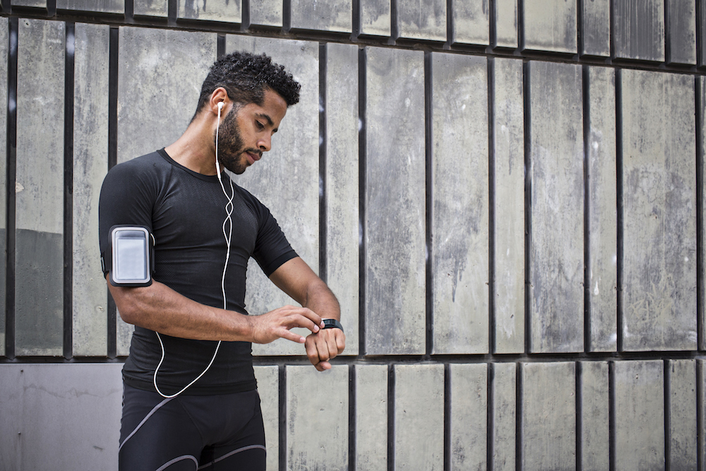 Young man setting up the smartwatch for the running session.