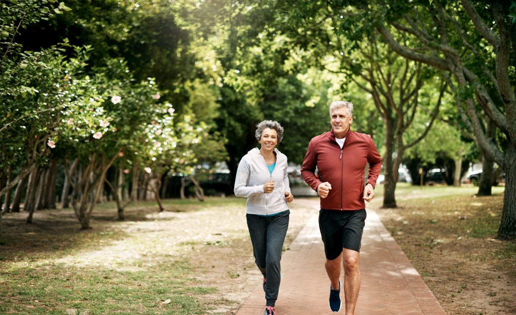 Full length shot of a senior couple taking a run through the park