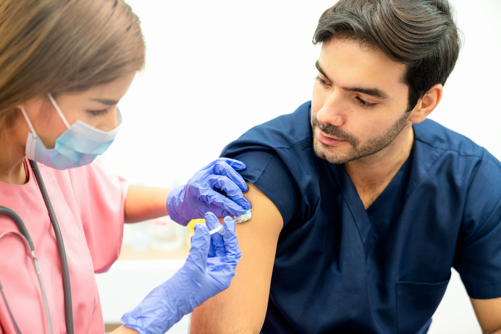 Nurse applying vaccine on patient's arm .She give patient vaccine or medicine injection.