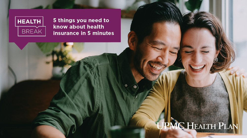 Couple looking at a notebook and smiling. Text overlay of "5 things you need to know about health insurance in 5 minutes"